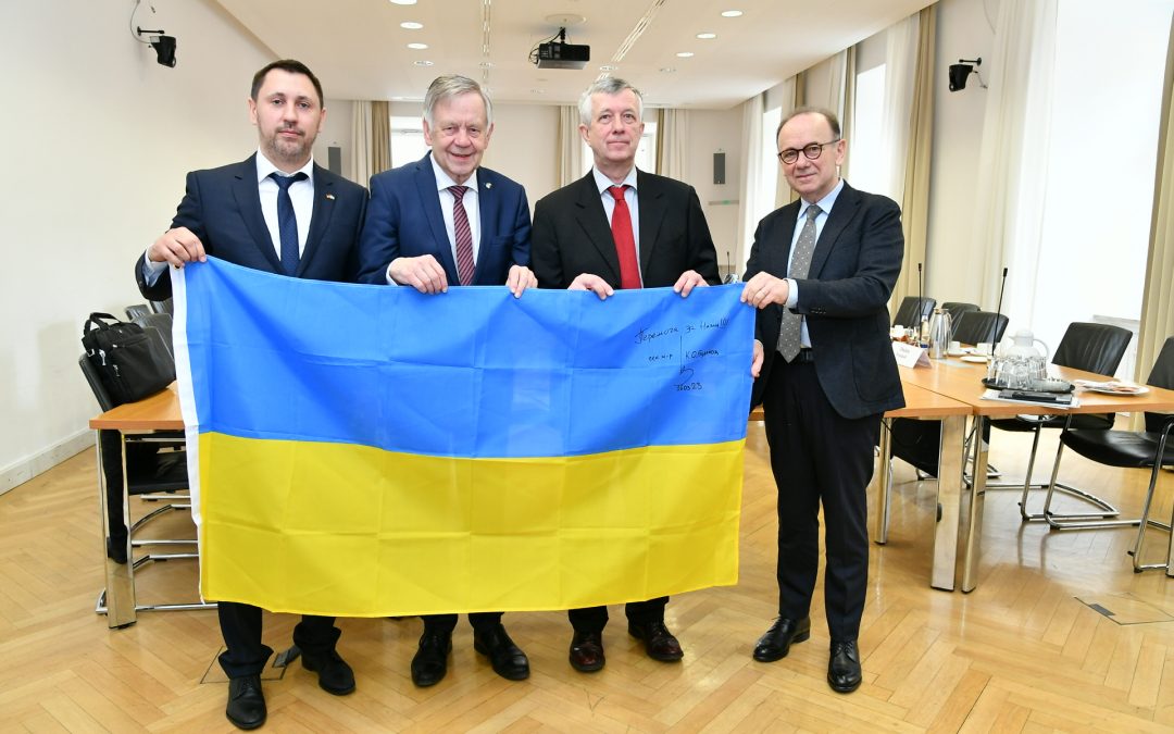 Karl Freller hält gemeinsam mit seinen Gästen die ukrainische Flagge hoch